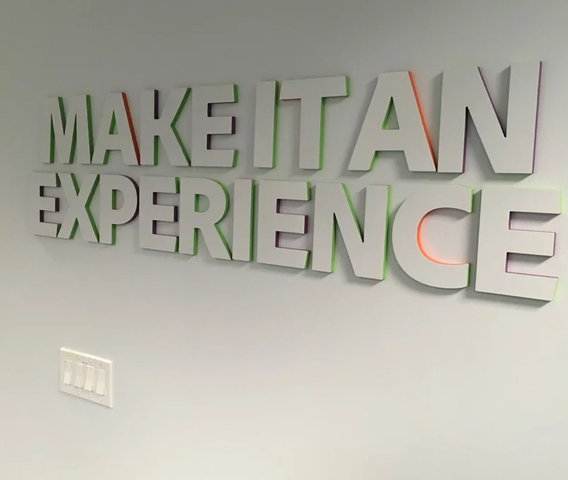 3D signage lettering with coloured edges stating "Make it an experience"