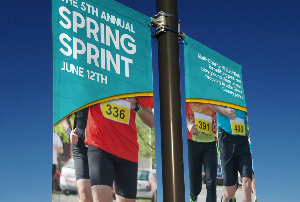 Two lamppost banners promoting a spring sprint event.